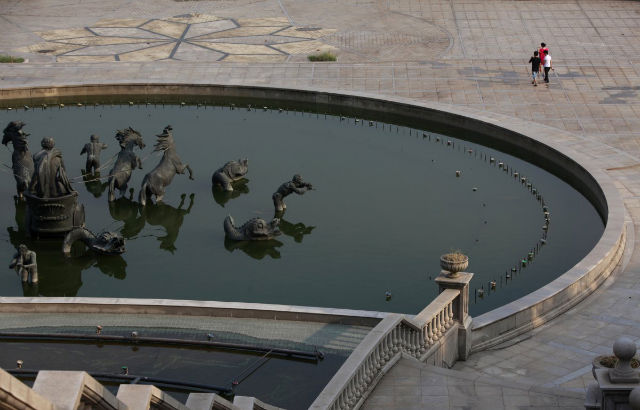 People walk past a fountain at the Tianducheng