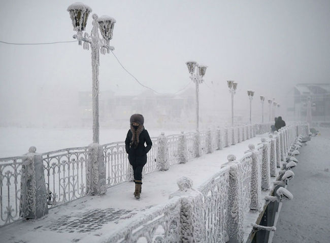 Lady walks down a frozen bridge