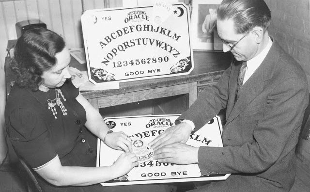 Man and woman playing Ouija board