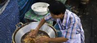 Picture Thai cook fries chicken burning-hot oil with his completely bare hands.