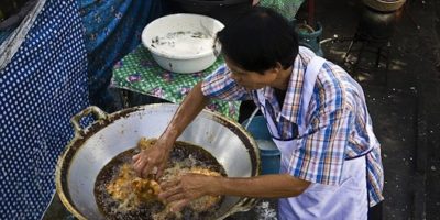 Picture Thai cook fries chicken burning-hot oil with his completely bare hands.
