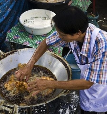 Picture Thai cook fries chicken burning-hot oil with his completely bare hands.