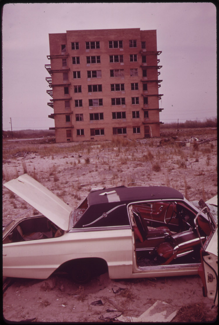 Abandoned Car and Unfinished Apartment House