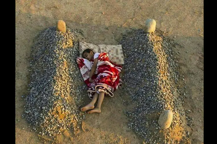 Syrian Boy Sleeping Between Parents' Graves