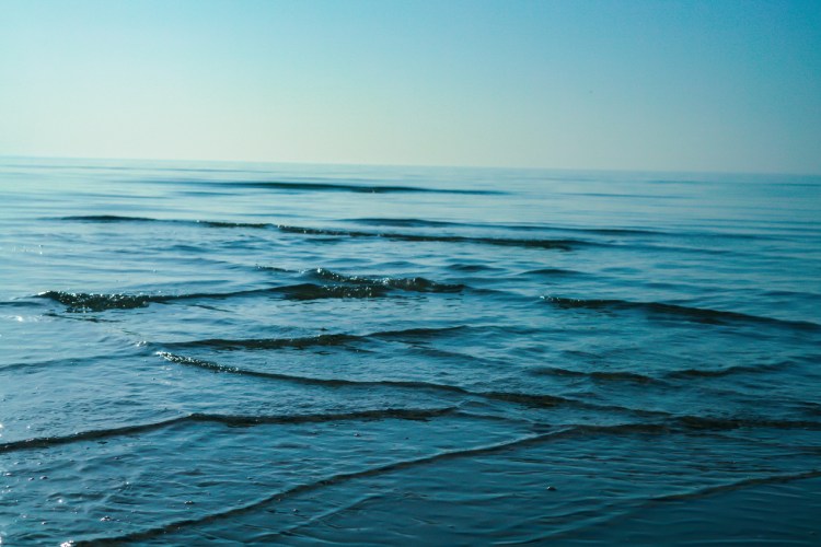 Waves gently intersecting in the ocean, forming a cross sea