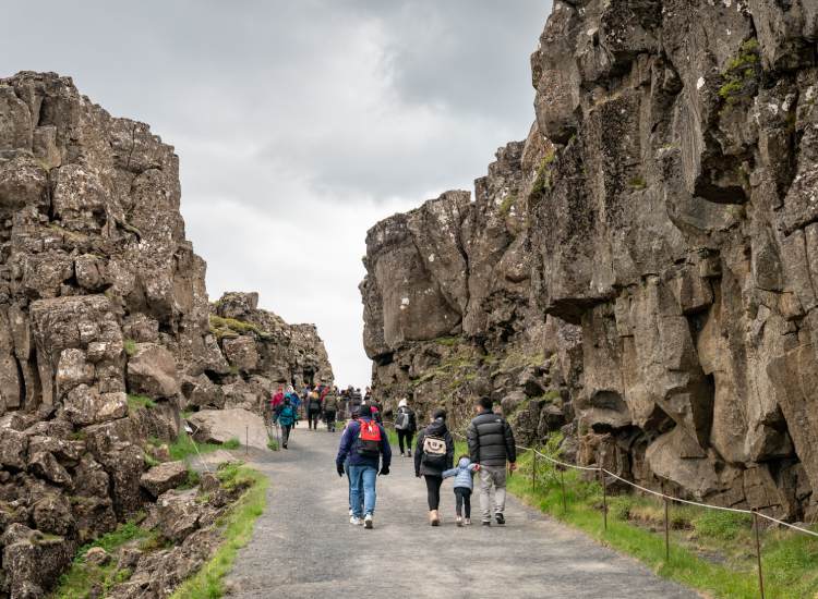 Visitors exploring Thingvellir National Park alongside the creek formed by tectonic plates.