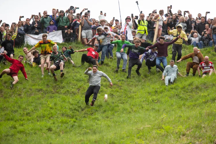 Participants chase the cheese during the annual cheese-rolling event Cooperâs Hill Cheese Rolling