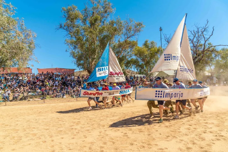 Participants competing in the dry boat race Henley-on-Todd Regatta